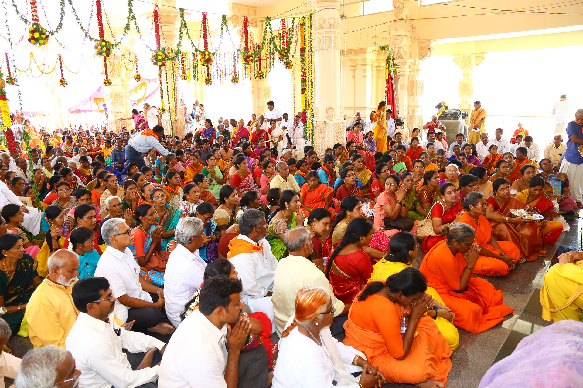 crowd of people in colorful outfits praying at Chinmaya Mission