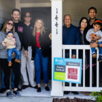 Park Square Homes team pose on the front porch of a new home