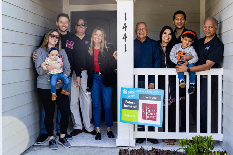 Park Square Homes team pose on the front porch of a new home