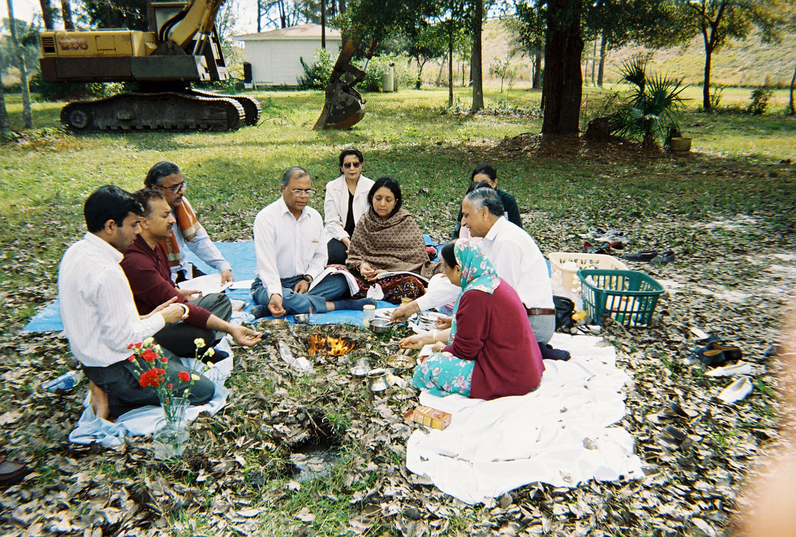 people sitting on the grass during a ceremony to bless groundbreaking