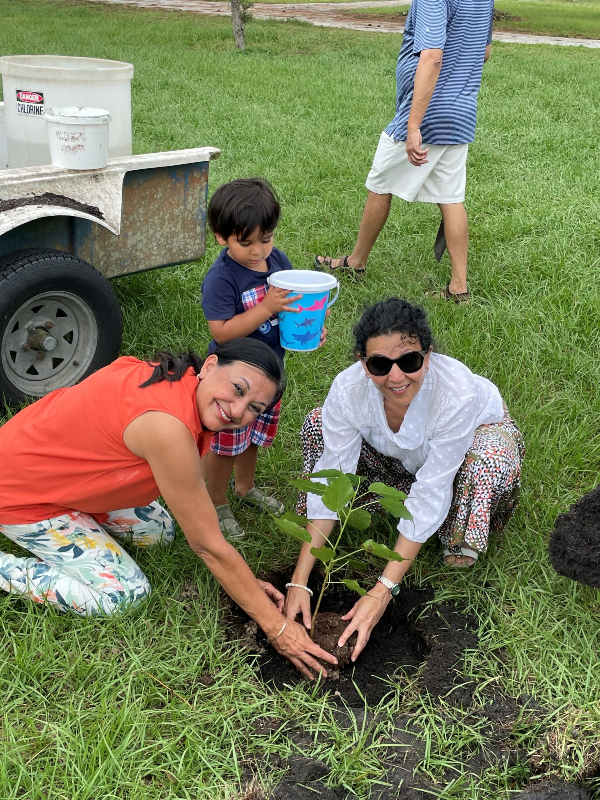 women and child plant a tree at Pine Lake Retreat groundbreaking