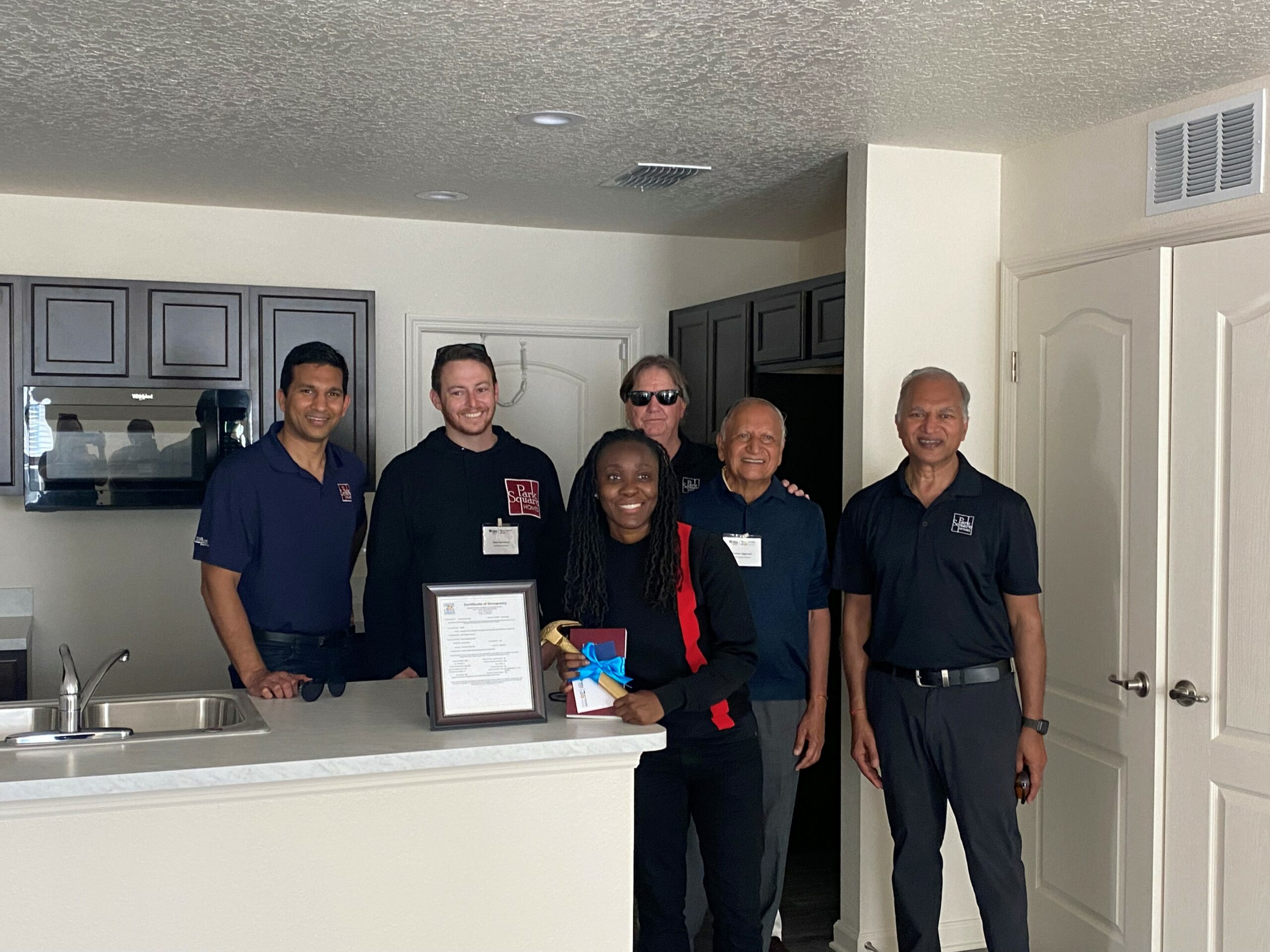 Park Square Homes members pose inside of a new home built during Habitat for Humanity Builder Blitz 2022