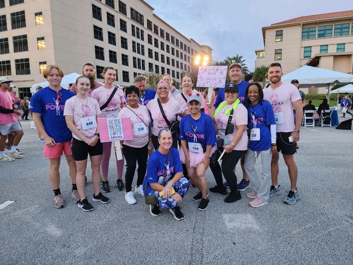 participants pose with signs and pink shirts to support Adventhealth Pink on Parade