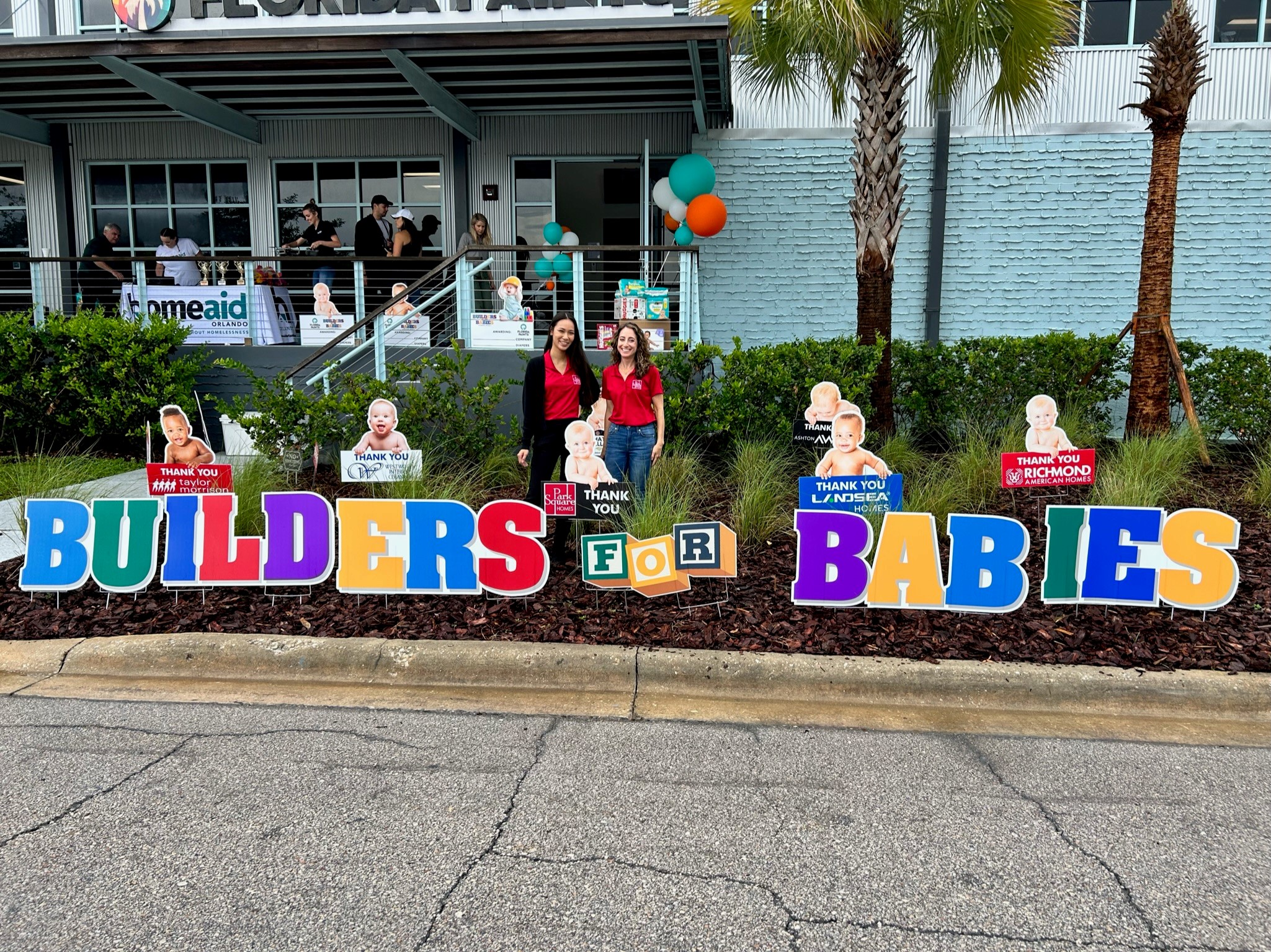 signs outside of a HomeAid Orlando building Builders for Babies Park Square Homes