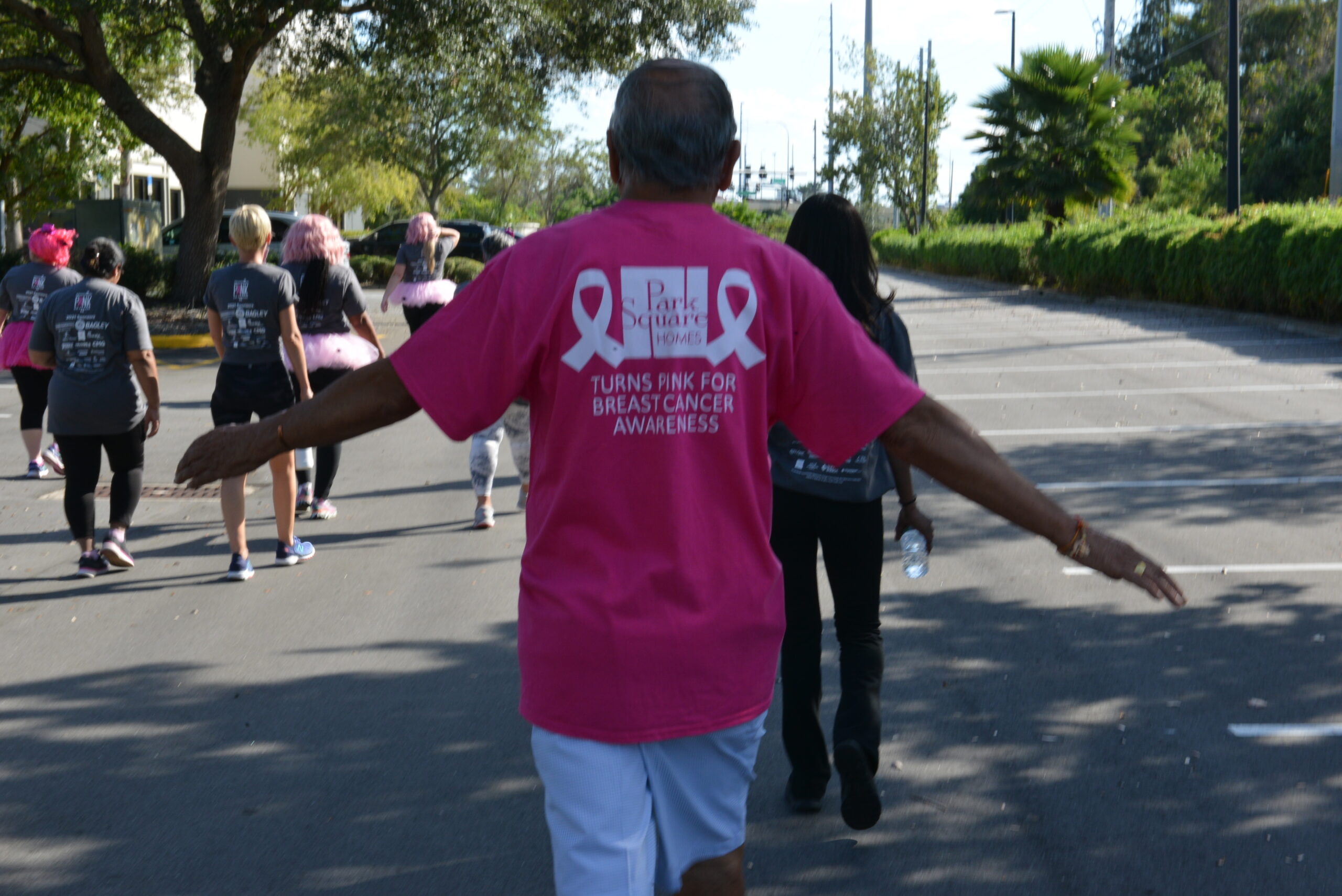 foundation member walking with Park Square Homes shirt Turns Pink for Breast Cancer Awareness