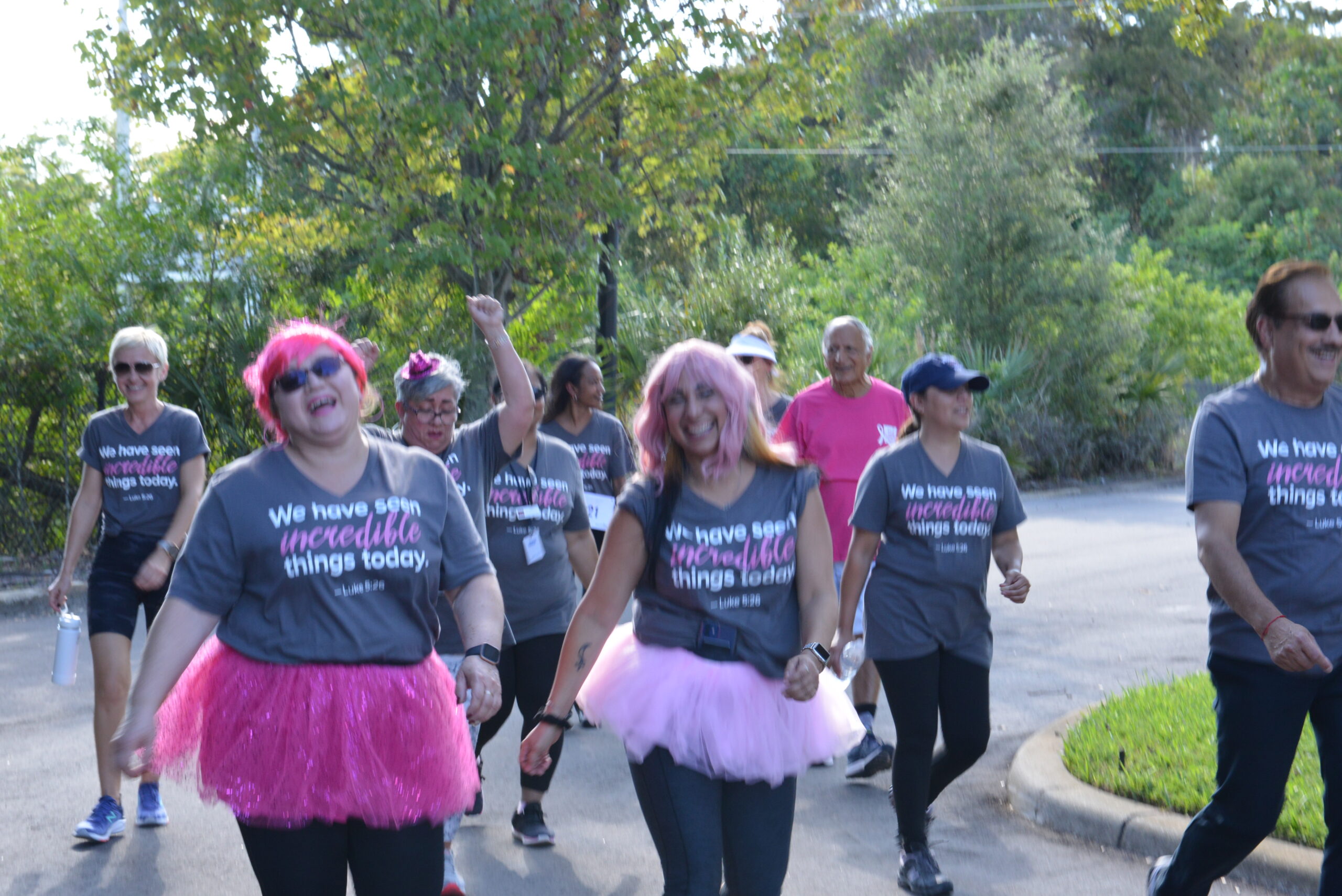 walkers along path wearing shirts We have seen incredible things today for Adventhealth Pink on Parade