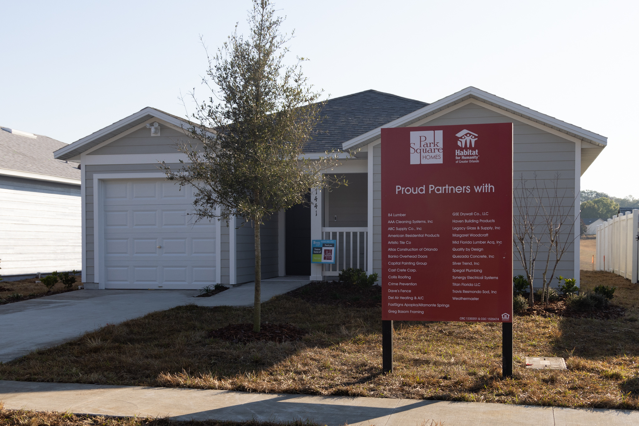 new home with Park Square Homes and Habitat for Humanity partner sign in front lawn