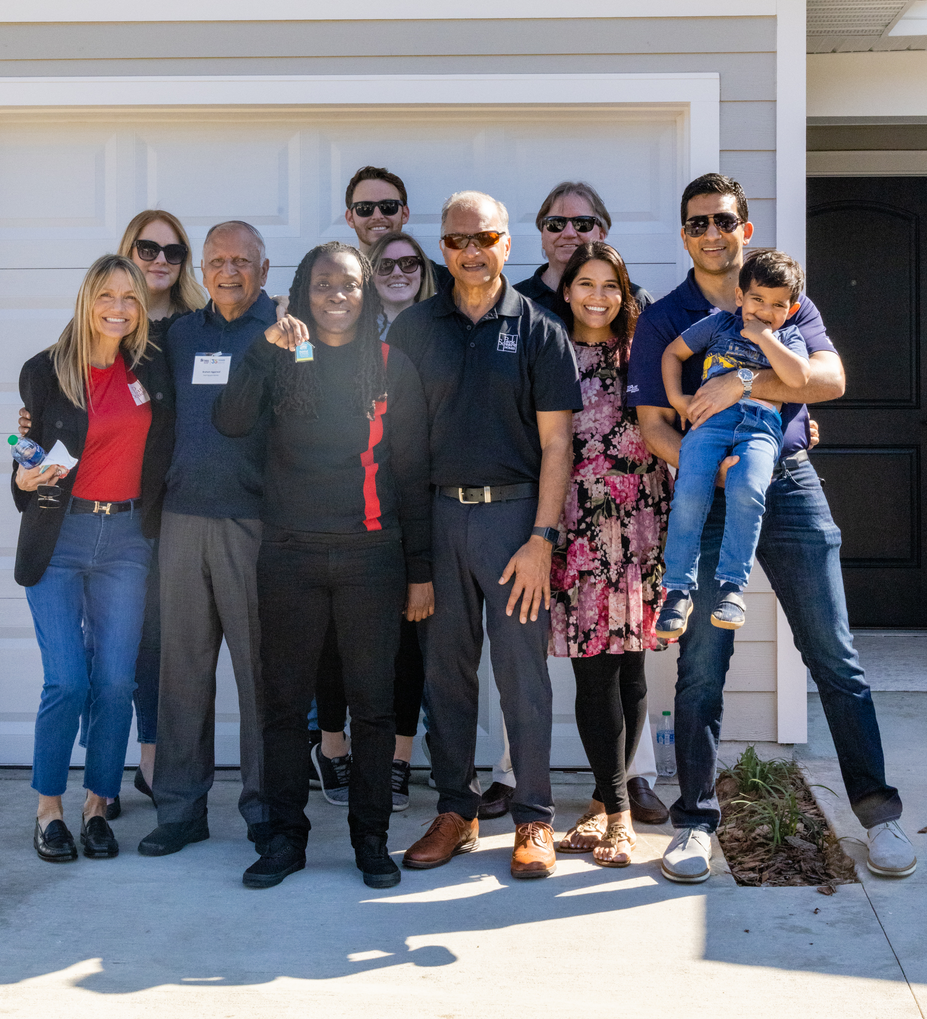 Park Square Home and families pose outside of a new home