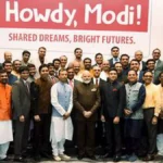 crowd stands in front of a sign that reads Howdy, Modi! Shared Dreams, Bright Futures