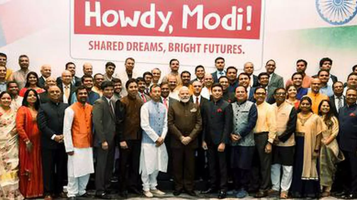 crowd stands in front of a sign that reads Howdy, Modi! Shared Dreams, Bright Futures