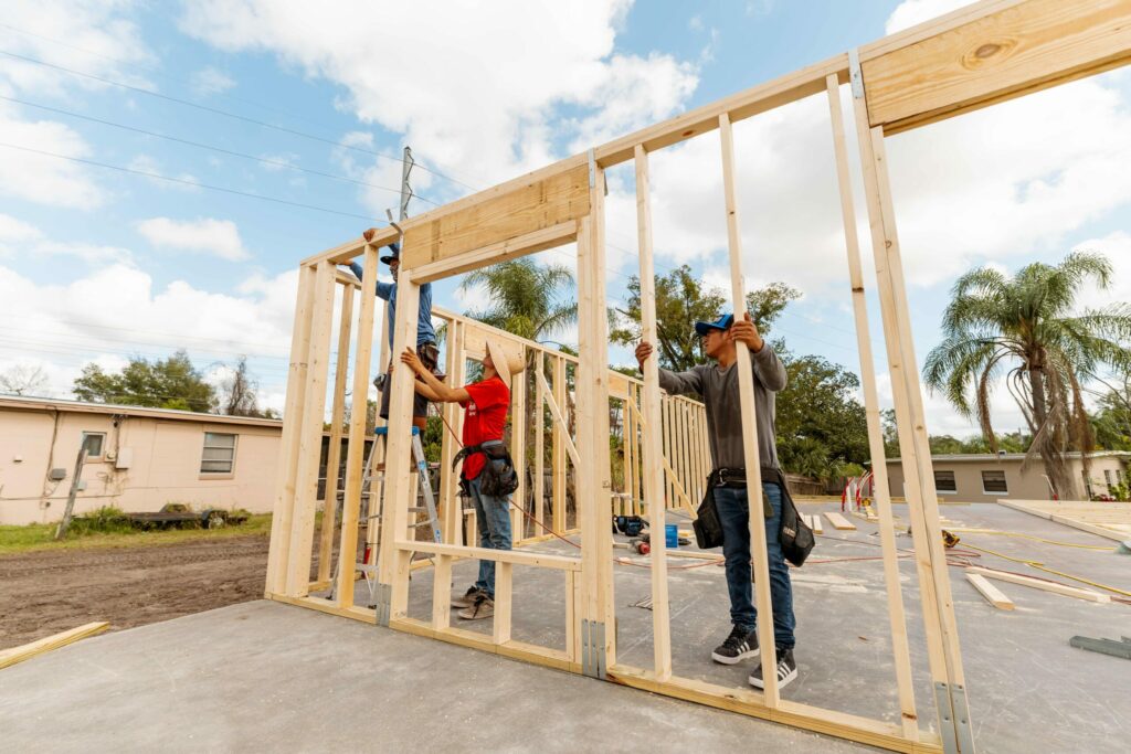 workers raise the frame of a house for Habitat for Humanity in Orange County