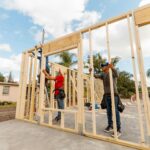 workers raise the frame of a house for Habitat for Humanity in Orange County