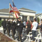 police with flags and crowd outside of a new home built by Park Square Homes for the Orlando Police Foundation